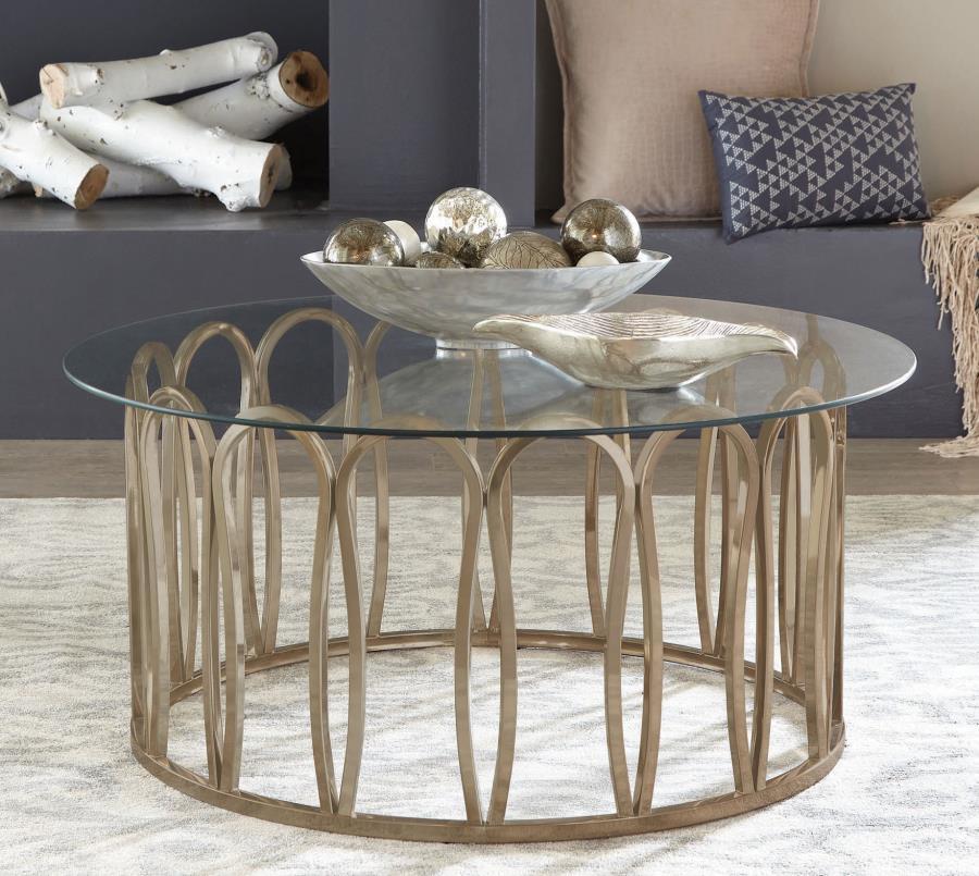 This round coffee table features a clear tempered glass top supported by a durable metal frame. The base is finished in a striking electroplated chocolate chrome, providing a deeper, rich brass tone. With its sleek design, this coffee table is an ideal ad