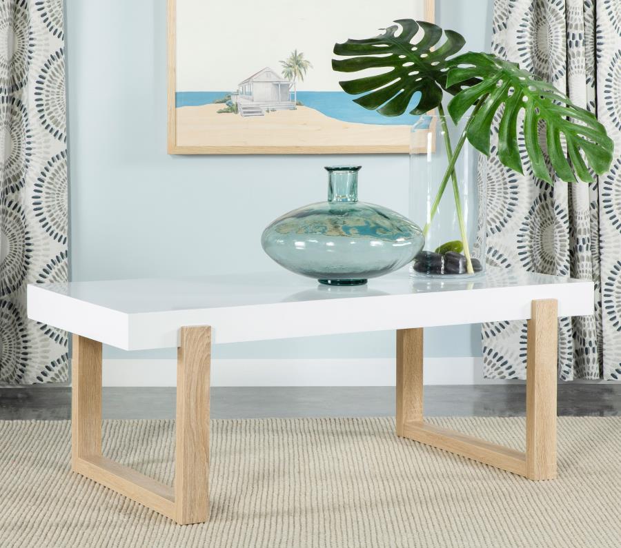 A spacious white high-gloss tabletop defines the modern appeal of this rectangular coffee table. The thick square-edged surface rests within a sled-style base supported by dual U-shaped legs. Crafted from engineered wood, its bright white hues contrast be