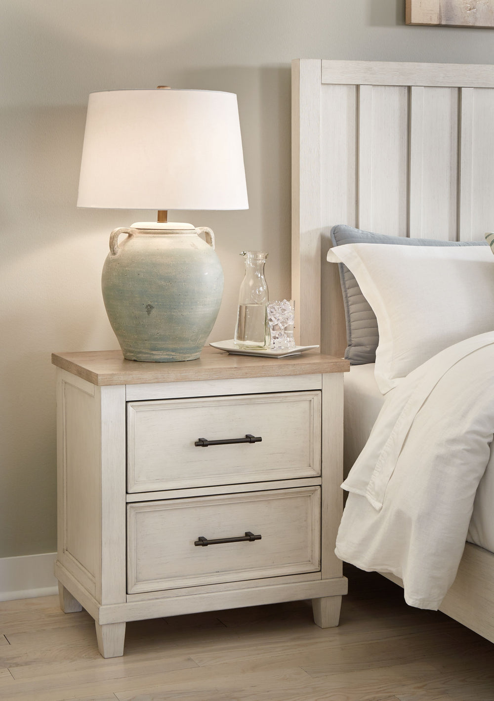 This nightstand elevates the art of modern farmhouse design. Its two-tone aesthetic blends antiqued white and light grayish brown for a charming finish. Two strikingly simple drawers lend a hand with conquering clutter, while AC power and two USB ports pr