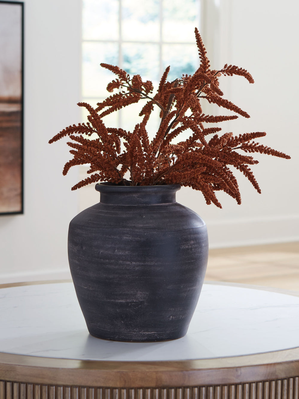 Celebrate the artisanal character of ceramics with this vase. Its distressed black finish has a time-worn, weathered appeal, offering the look of the past with a modern feel. The vase-'s neutral tone makes it a go-to for all seasons, allowing you to stage