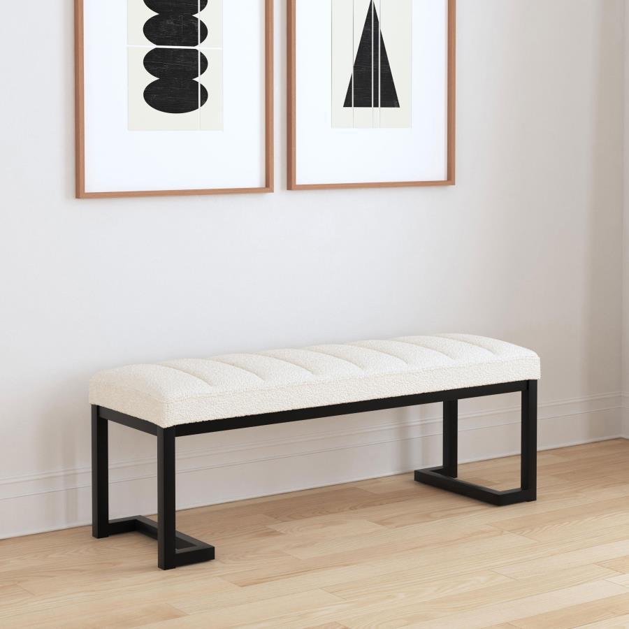 Textured upholstery play perfectly with the modern silhouette of a backless accent bench. Its deep black finished frame is constructed in metal for excellent durability, with a bracket inspired silhouette that emphasizes its contemporary design credential
