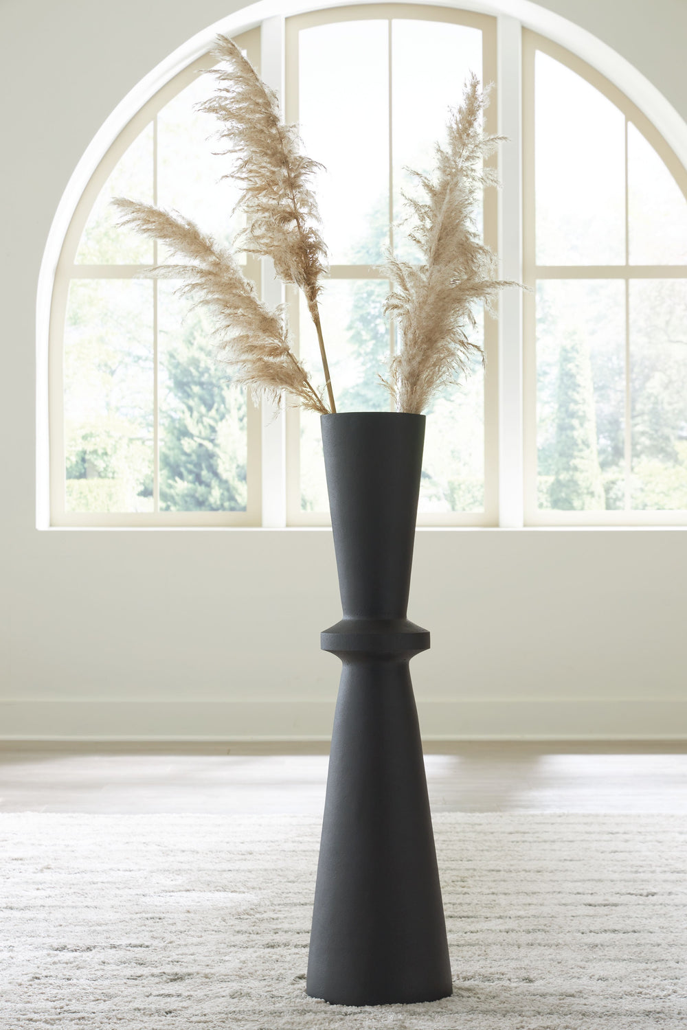 Crafted with contemporary spaces in mind, this black-hued vase is a versatile addition to your decor. Its hourglass shape and textured pattern make for an eye-catching standalone piece. Chic in an office corner or greeting guests in the entryway, this vas