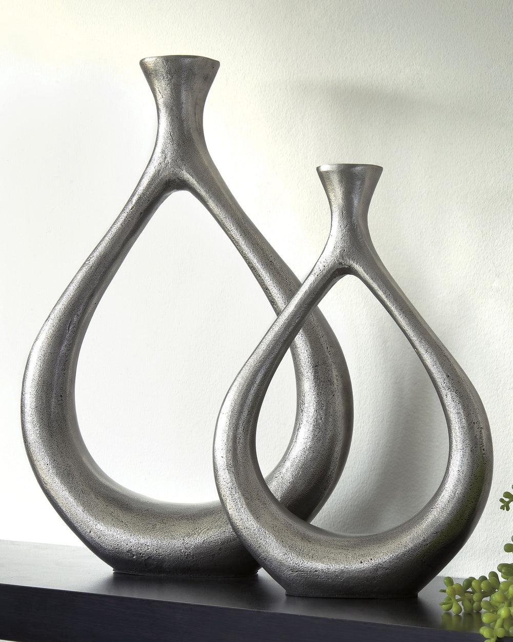Make a splash with this vase set. The teardrop design with a cutout center is so eye opening. An antiqued silvertone finish is a striking contrast to the vasesâ€™ modern flair.<br><br><b>Additional Dimensions</b><br><ul><li>Vase-small: 0-"</li><li>Vase-la