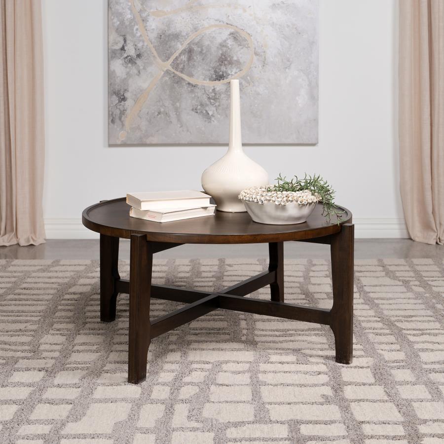 Circled by the day-'s activity, the coffee table is a cocktail centerpiece that grounds the room in solid wood durability. Its dark brown finish glows under the touch of light, inviting a caress to its smooth, subtly recessed surface. The strong, intersec