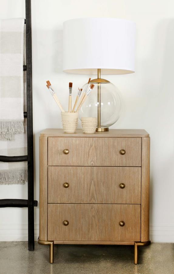 Retro-inspired elements come together in this mid-century modern, three-drawer nightstand, designed with a wire-brushed, sand wash finish and adorned with aged brass round knobs and slender metal tube legs. Extra thoughtful details such as a built-in dual