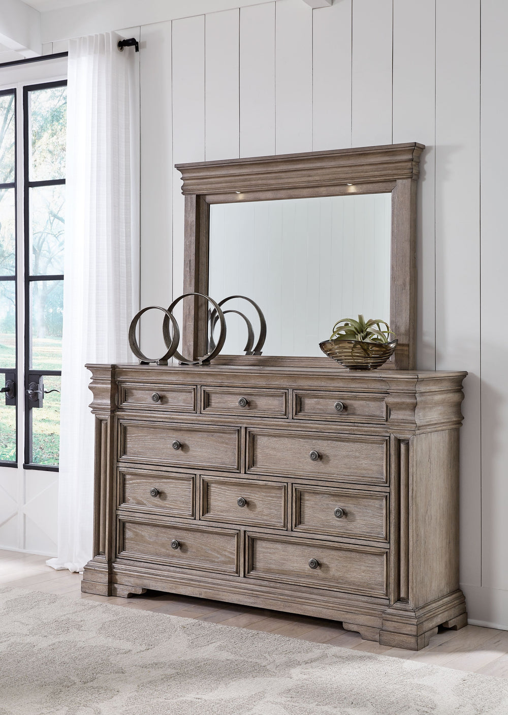 Discover something exceptional in this dresser with mirror. Its impressive silhouette offers a casual traditional aesthetic, embodied by classic-inspired profiles and a relaxed grayish brown finish. Inset framed drawers of various sizes are casually cool 