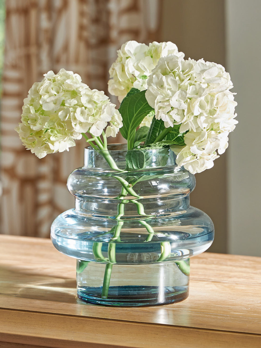 This contemporary vase is anything but ordinary. Displayed on its own or with faux greenery, the statement-making accentâ€”crafted from blown glass in a blue hueâ€”rounds out your modern decor beautifully.<br/><br/><b>Product Features</b><ul><li>Made with