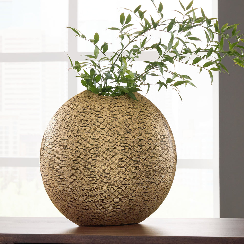 This vase offers a unique take on contemporary stylings. An antiqued goldtone finish has a glam appeal, while the rounded form gives it geometric character. Equally as artistic displayed on its own or with faux greenery, this vase is a statement-making ad
