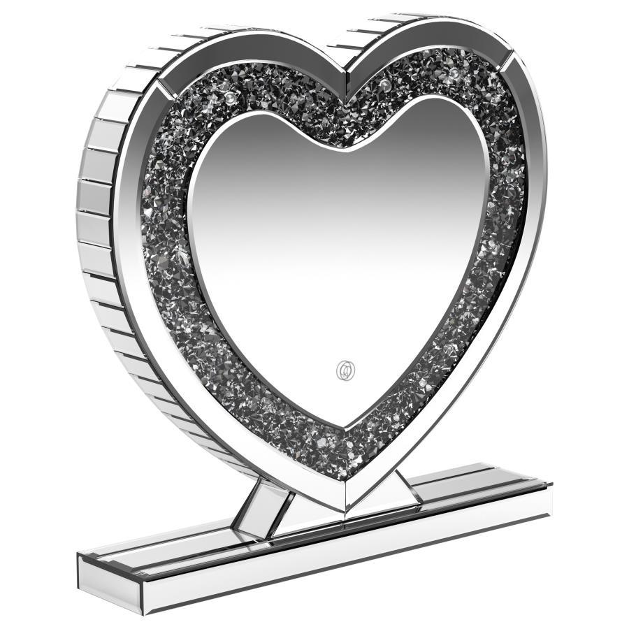 This heart-shaped table mirror blends glam style with practical lighting, perfect for vanities or dressing areas. The mirrored frame features an inset of faceted acrylic crystal inlay that catches light beautifully, while integrated LED illumination adds 