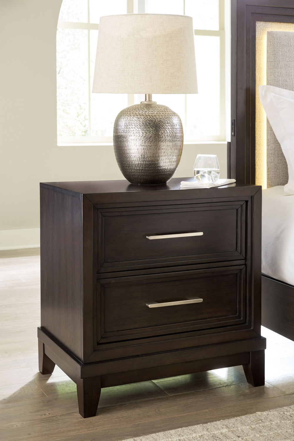 This nightstand combines modern and art deco styles for both traditional and contemporary arrangements. With elegant stepped moulded framing and two spacious drawers, it adds dimension to your sanctuary while keeping your belongings organized and clutter-