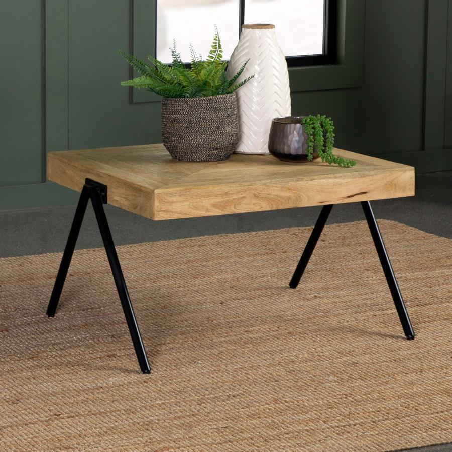 Enhance your living space with this rectangular coffee table, crafted from solid mango wood and finished in a natural tone to highlight its unique grain patterns. Its sturdy iron legs, coated in a sleek black powder finish, offer lasting durability and a 