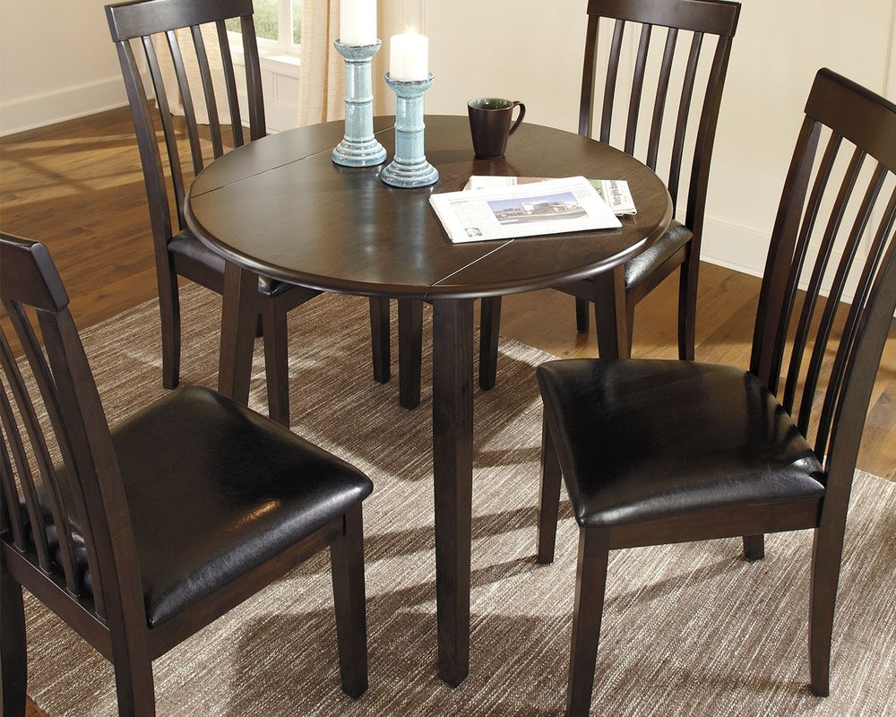Made with select birch veneer and hardwood solids in a transitional dark brown finish with gray undertones. Compact table seats four and includes drop leaves for multi-function. <h4><b>Hammis - Dark Brown - Round DRM Drop Leaf Table</b></h4> <table width=
