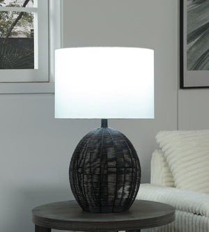  featuring a rounded black rattan base that adds visual intrigue. Paired with a sturdy metal frame for durability and a neutral fabric shade for soft
