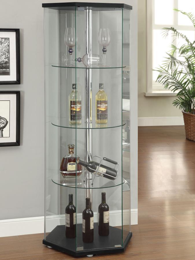 Explore the cutting edge properties of geometric design. Made from glass, this curio cabinet wakes up a contemporary space and puts a new spin on an old classic. Hexagonal in shape, it features a cool center pole for visual effect. A black finish top and 