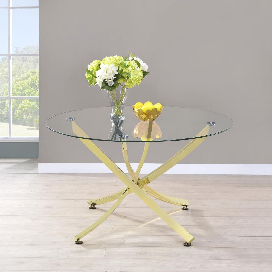 This round dining table offers a striking balance of clarity and form. A clear tempered glass top creates an airy presence, while the sculptural asterisk-style base adds dramatic visual interest. Crafted from heavy gauge metal, the base is electroplated i