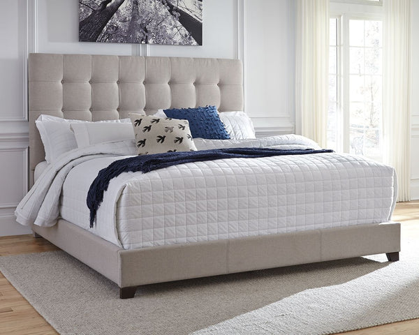  a pale beige fabric hugs the bedâ€”from the chic headboard with square button tufting