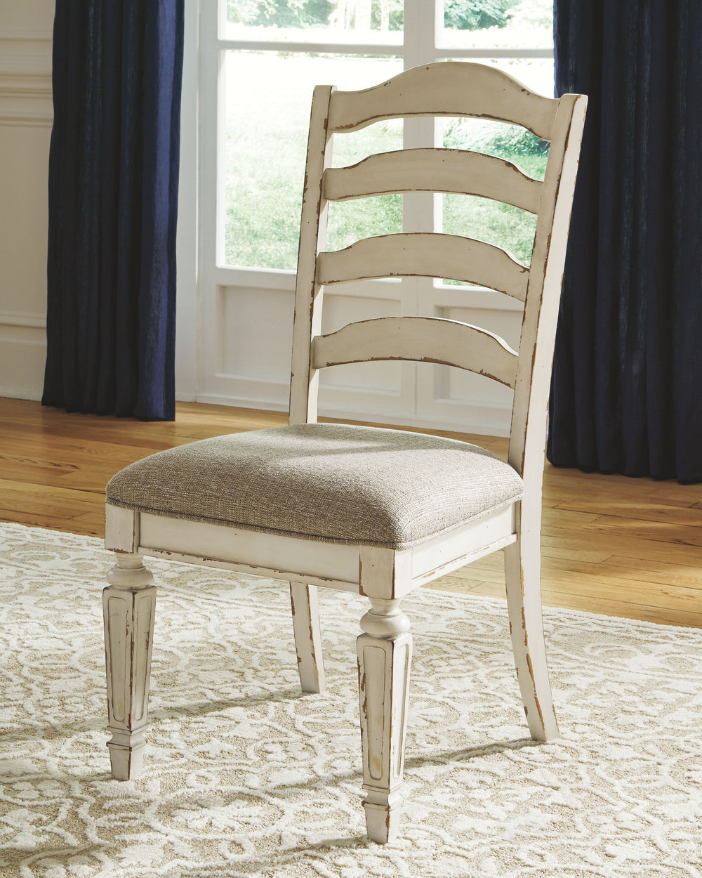 Bon appÃ©tit. With its rounded ladderback styling, chipped white finish and plushly cushioned seat, the Realyn dining room chair has all the right ingredients for a French country-inspired feast for the eyes.<br><br><b>Additional Dimensions</b><br><ul><li
